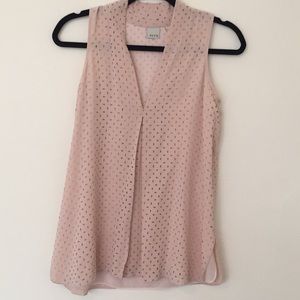 Ecru sleeveless blouse.